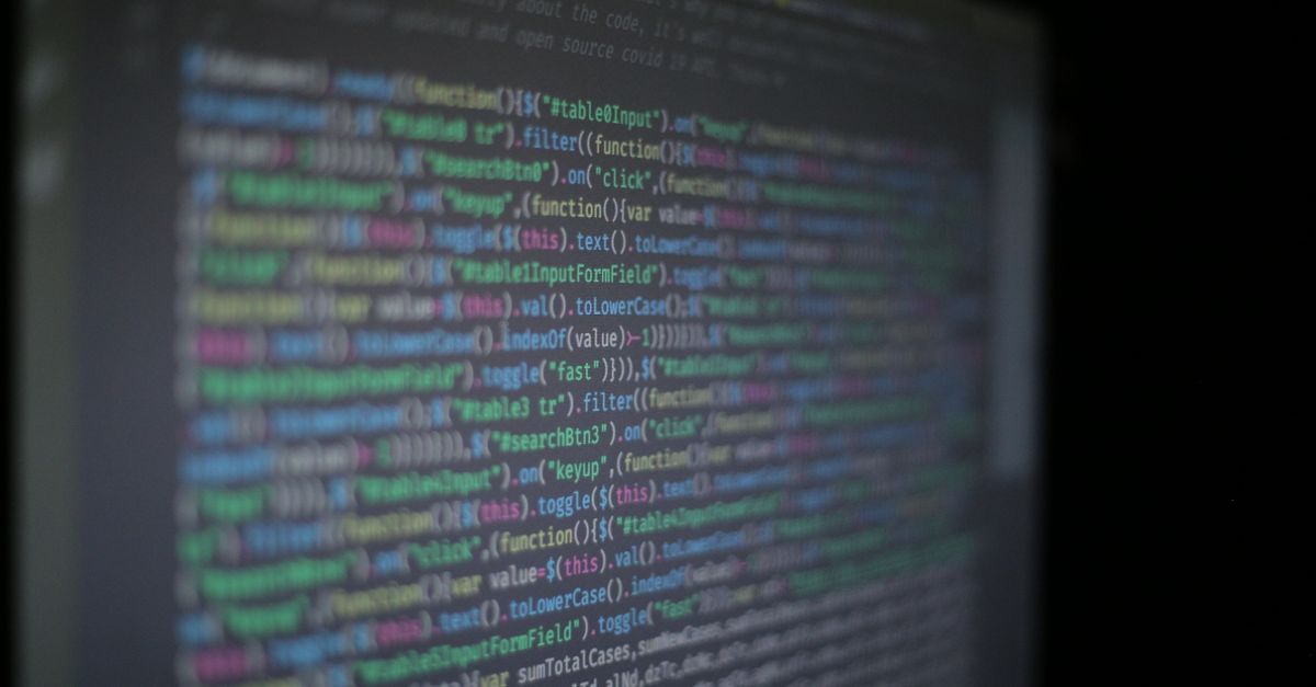 Close-up of colorful programming code on a blurred computer monitor.
