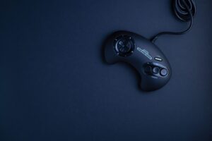 Navy blue vintage game console controller photographed from above on a dark background