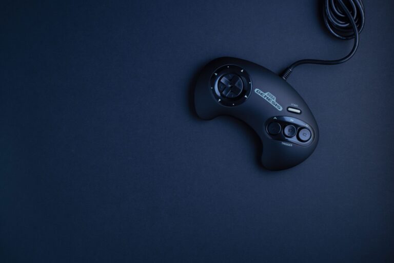 Navy blue vintage game console controller photographed from above on a dark background