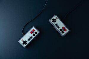 Two retro gaming controllers on a dark background, vintage console gaming