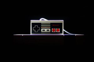 Classic NES controller with dramatic lighting on a black background, evoking retro gaming nostalgia