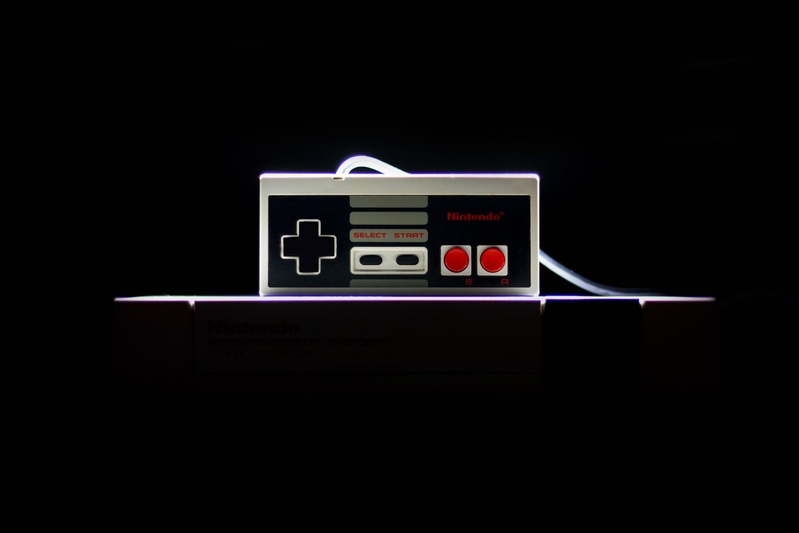 Classic NES controller with dramatic lighting on a black background, evoking retro gaming nostalgia