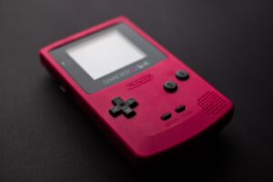 Red Nintendo Game Boy handheld console on a clean background, classic retro gaming on a budget
