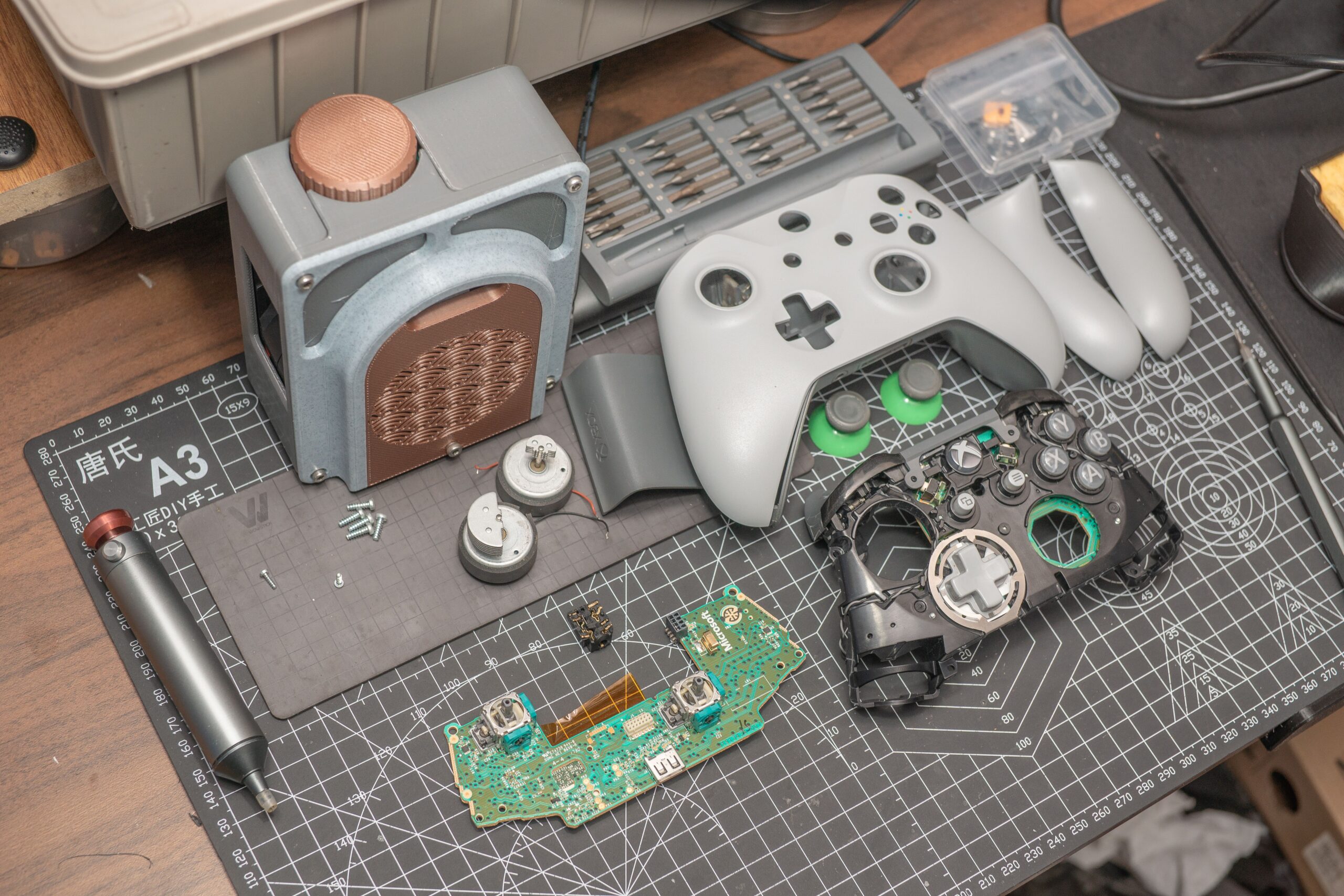 Controller di una console retro smontato con componenti elettronici su un tappetino da lavoro per riparazione e modding