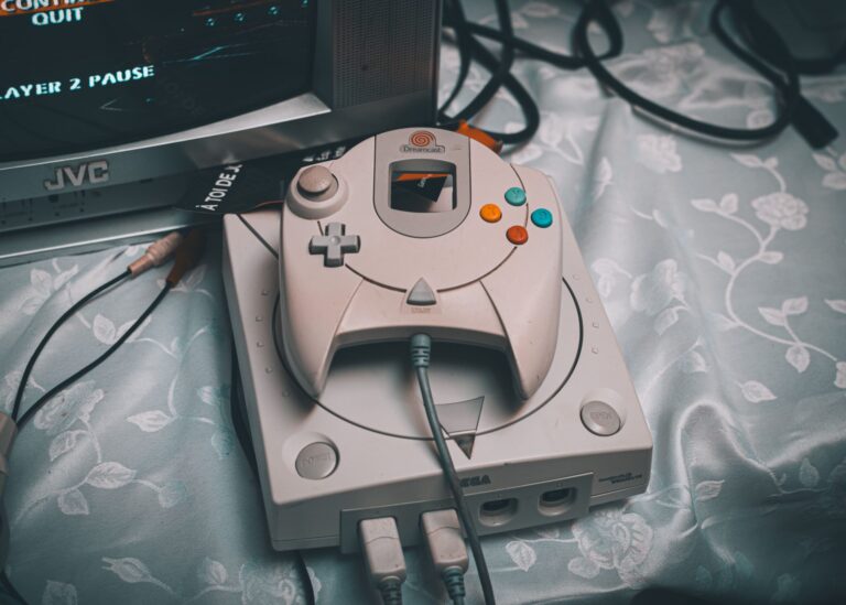 Sega Dreamcast console with controller on a vintage retro gaming setup