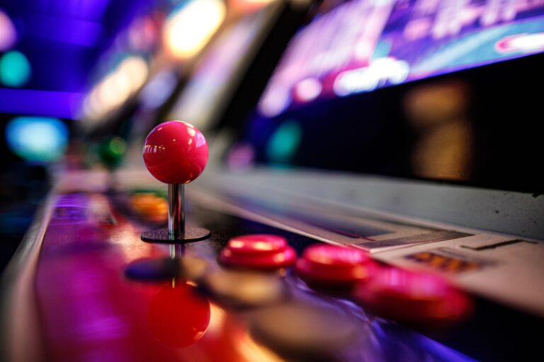 Vibrant retro arcade joystick and buttons with blurred neon lights in the background