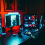 Game developer al lavoro su postazione multi-schermo per sviluppare videogiochi