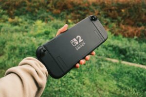 Hand holding a Nintendo Switch console outdoors, perfect for retro gaming on the go