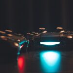 Game controller illuminato su superficie scura, lancio e pubblicazione di un videogioco su Steam