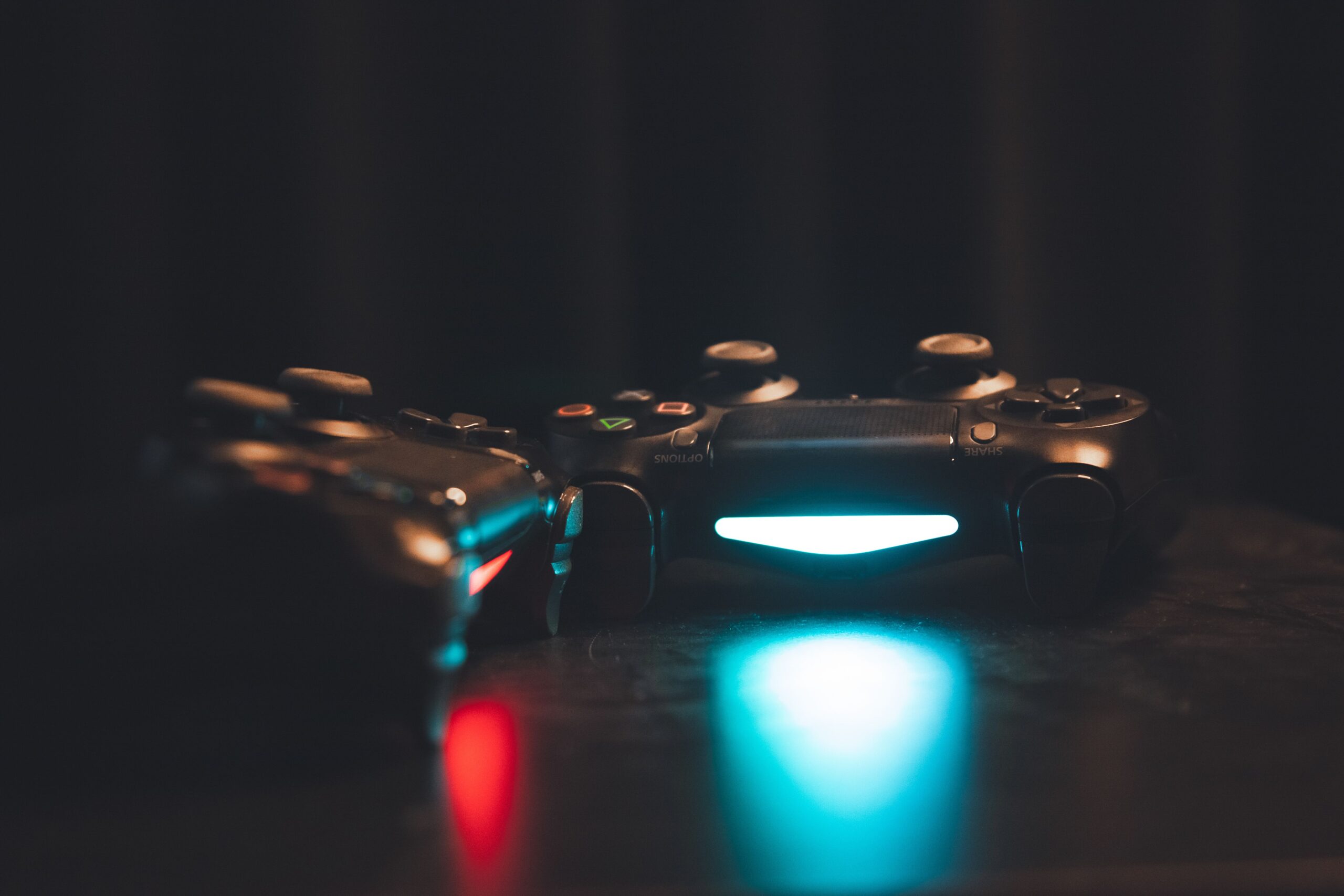 Game controller illuminato su superficie scura, lancio e pubblicazione di un videogioco su Steam