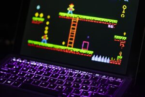 Laptop running a retro video game on Linux with a neon-lit keyboard
