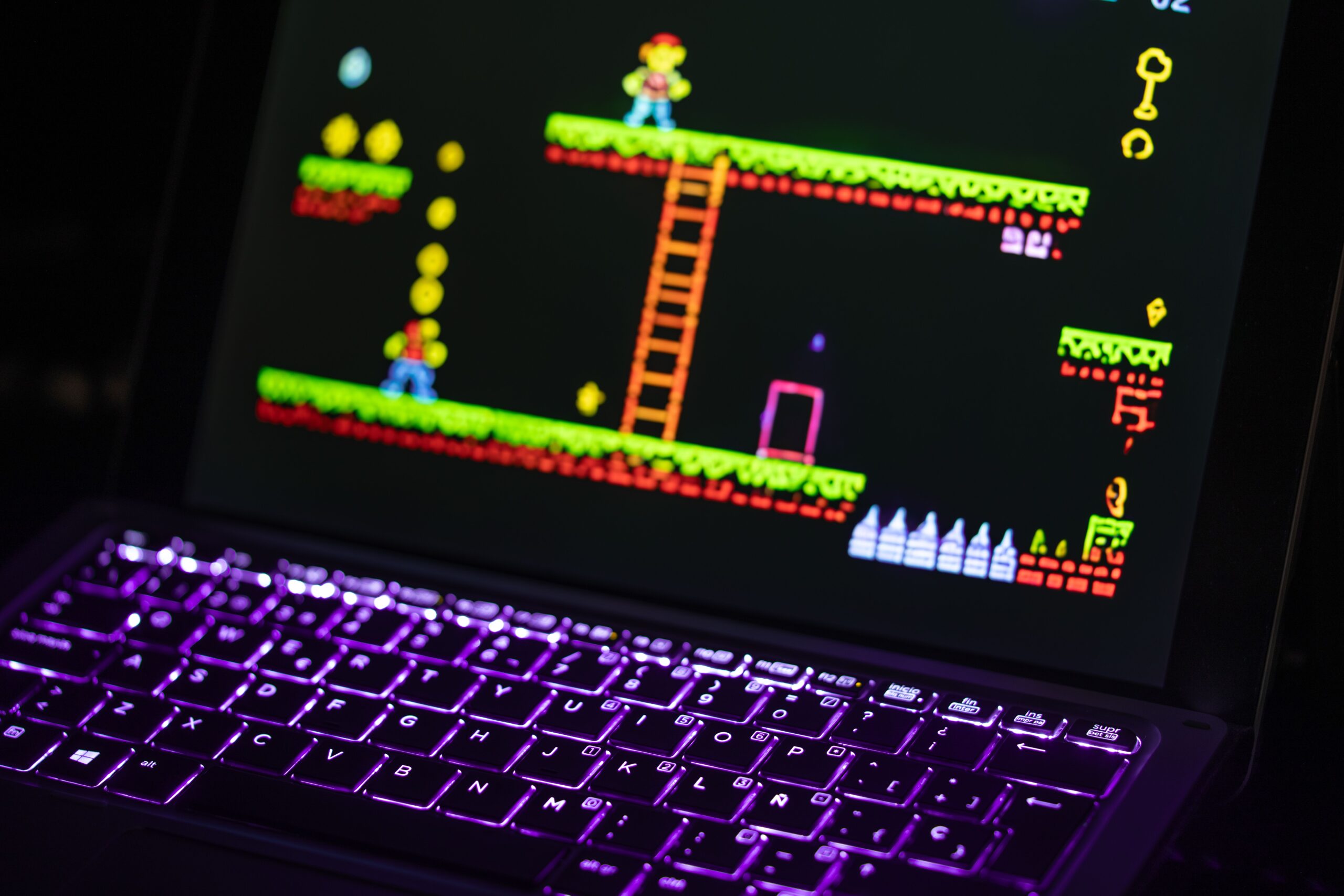 Laptop running a retro video game on Linux with a neon-lit keyboard