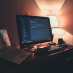 Postazione di sviluppo videogiochi con doppio monitor e codice di programmazione, guida completa game development