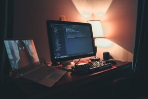 Postazione di sviluppo videogiochi con doppio monitor e codice di programmazione, guida completa game development