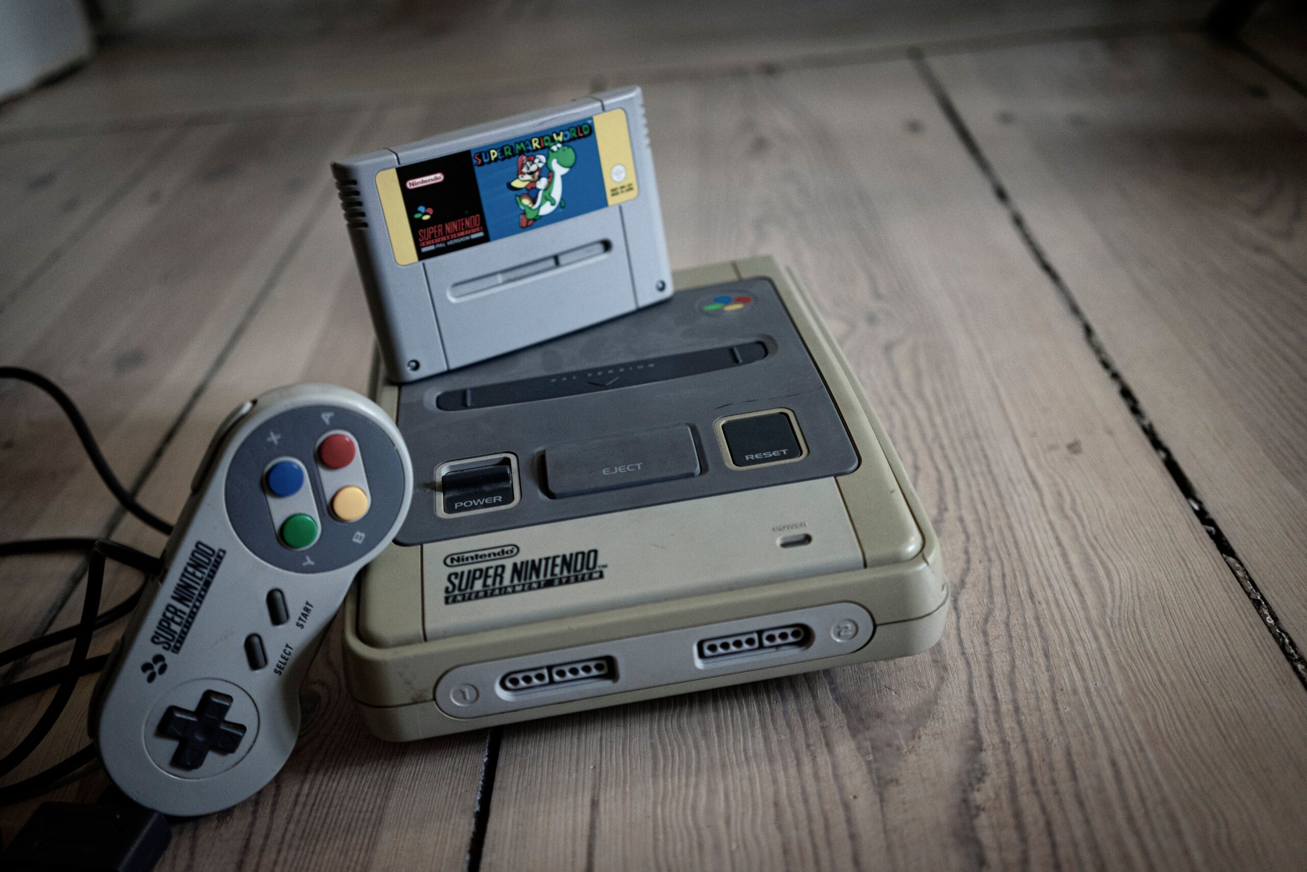Vintage Nintendo 64 game console with cartridge and controller on a wooden surface