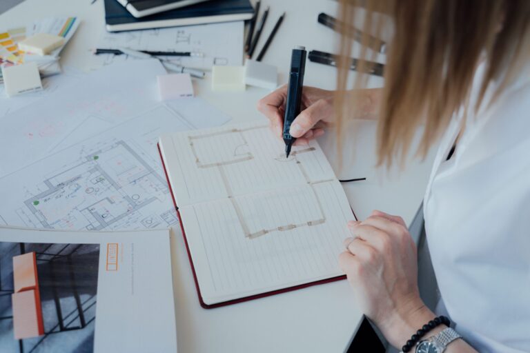 Game designer che pianifica il progetto e scrive il game design document sul tavolo di lavoro