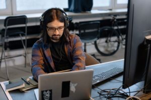 Game developer al lavoro in ufficio con computer, stipendi e carriera nell'industria dei videogiochi