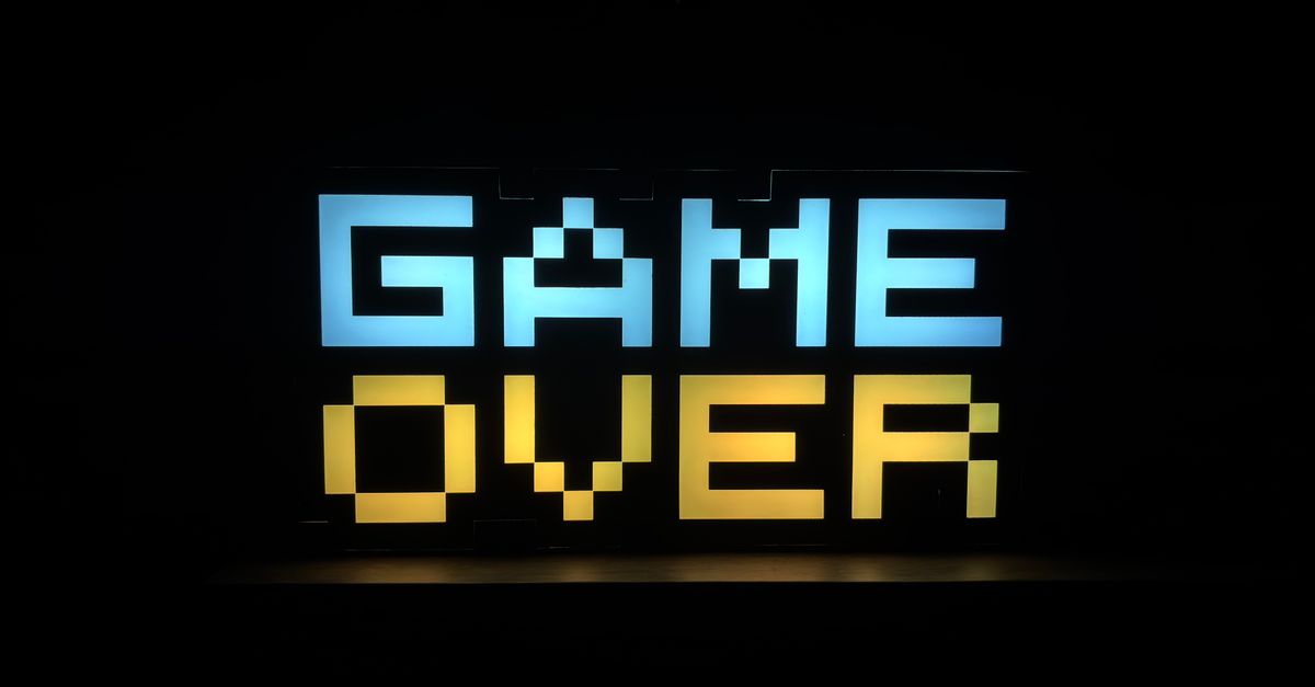 Illuminated pixel art 'Game Over' sign with vibrant colors against a black background.